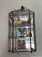 Full view of glass display cabinet hanging on wall with contents visible