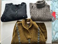 Group shot of all three sweaters folded