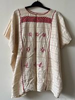 Full view of vintage Mexican cotton huipil blouse on hanger