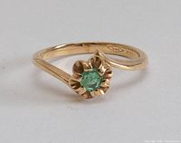 top view showing ring design, green stone and 14k hallmark