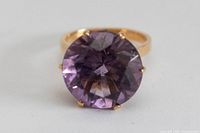 Front view of ring showing large round faceted amethyst and prong setting