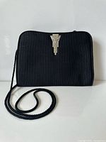 Front view of black corded evening bag with strap visible
