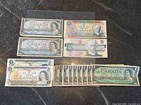 All banknotes laid out showing denominations and years