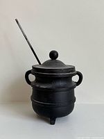 Front view of cast iron fire starter pot with wand inserted