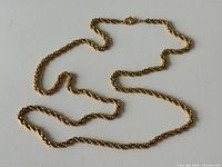 Full view of gold-tone rope chain necklace laid flat