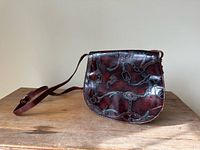 Full view of leather purse with strap displayed