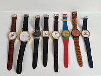 All eight wristwatches laid out side by side strap extended