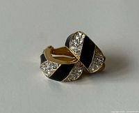 Front three-quarter view showing enamel and rhinestone design