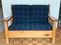 Front view of pine loveseat with plaid cushions