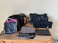 Group of assorted purses and wallet on wooden surface