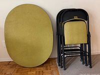 Table folded upright beside stacked folded chairs