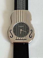 Front view of guitar-shaped Wittnauer watch showing dial, case details, strap