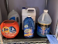 Front view showing all five cleaning product containers on shelf