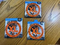 Front view of three sealed D'Addario EJ22 XL string packs