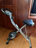 Full view of foldable upright bike showing frame, seat, pedals, stabilizers