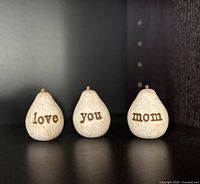 Three white resin pear figurines spelling “love you mom”