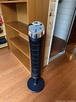 Full view of Honeywell QuietSet tower fan standing on round base