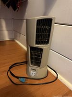 Front view of grey Lasko desktop wind tower fan with power cord visible