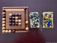 Full lot showing wooden Pylos board with spheres and two pouches