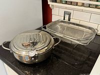 Pot closed with lid and thermometer beside mesh basket