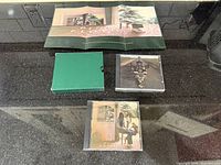 All components: folded poster, green slipcase, two CD cases