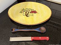 Platter, measuring spoon and knife grouped on countertop