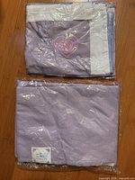 Two sealed lavender fabric pieces, one with heart embroidery