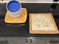 Stacked bowls on bamboo board next to floral tile trivet