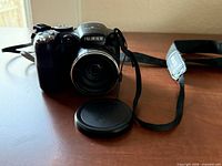 Front view of Fujifilm FinePix S2950 with lens cap foreground