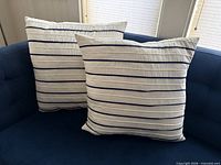 Two striped Hilfiger pillows on sofa