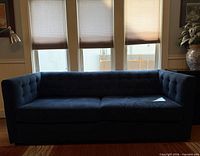 Front view of navy velvet tufted sofa showing overall design and color