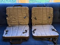 Both stadium seats opened flat showing quilted cushions and side straps
