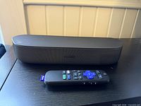 Front view of Roku Streambar with remote placed in front