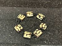 Full view of stretch bracelet showing six batik bone tiles and spacer beads