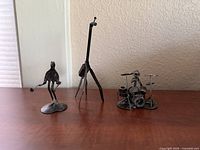 Wide shot of three welded metal sculptures on tabletop