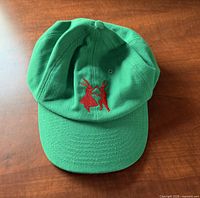 Front view of green baseball cap showing rabbit embroidery