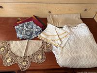 All linens laid out: tablecloth, napkin sets, crochet collar doily