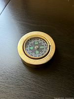 Top view of brass tabletop compass showing dial and bezel