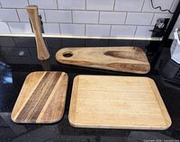 Overview of three cutting boards and muddler on countertop