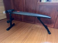 Side view of Weider adjustable workout bench showing full frame, padding and leg rollers