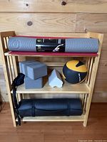 overall view of rack with mats, blocks, strap, wedge, medicine ball