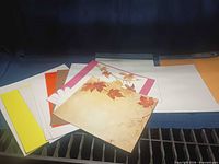 Stack of assorted 12 x 12 cardstock and scrapbook papers showing various colours and prints