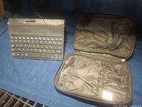 Keyboard in folio next to zip case, shows overall lot