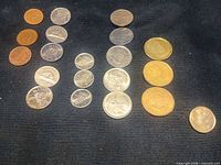 All coins laid out by denomination on dark fabric