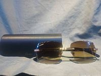 Front view of Cartier rimless sunglasses with brown gradient lenses and case