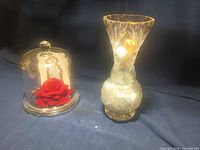 Wide view of glass cloche with rose and card next to lit cut glass vase