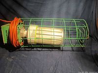Full view of green caged LED corn light with cord wrapped