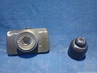 Front of dash camera and separate mount on blue background