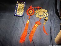 Tray and two red tassel charms laid out