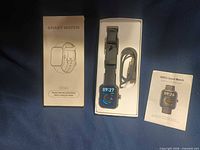 Watch, box, charging cable and manual laid out